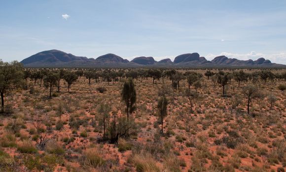 Desert landscape leads to Ayers Rock in Australia