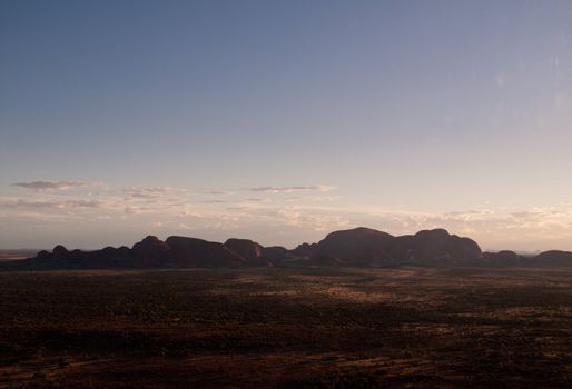 Sun setting over the plain in front of Ayers Rock in Australia