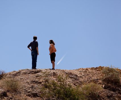 Male and female hikers in Anze Borrego desert point to distant object