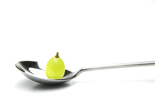 Grapes on a spoon isolated against a white background