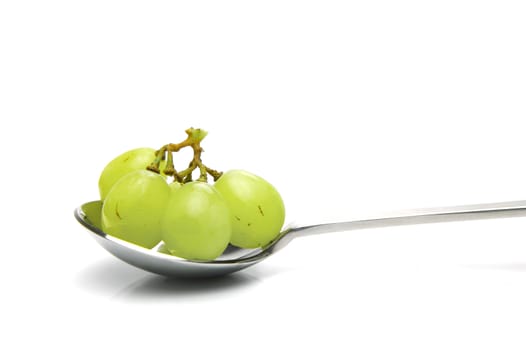 Grapes on a spoon isolated against a white background