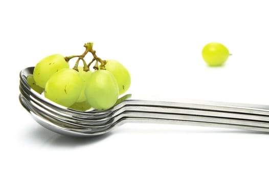 Grapes on a spoon isolated against a white background