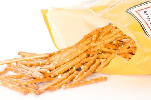 An open bag of pretzels with contents pouring out.