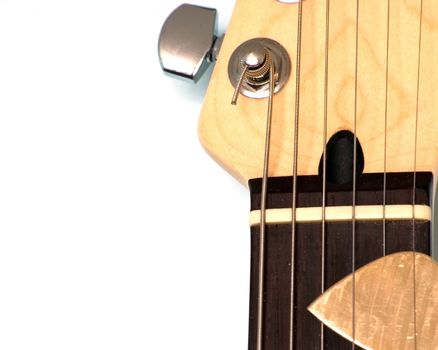A section of a electric guitar head stock with pick in the strings.