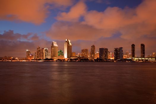 Sunset on San Diego skyline with city lights reflected in clouds taken from Coronado