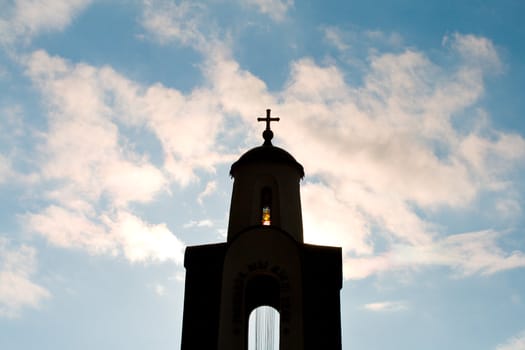 monument with cross on blue sky background