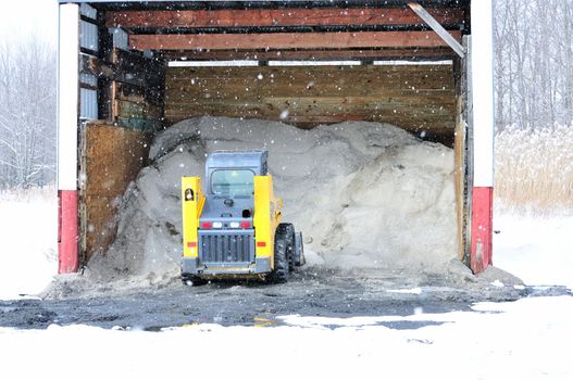 A road salt shelter loaded with salt and a salt loader.