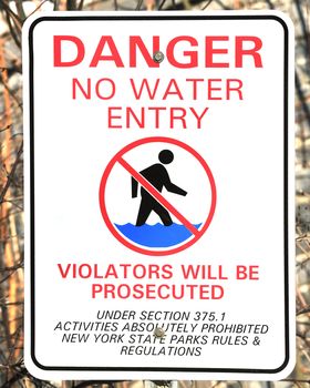 A water hazard warning sign displaying local ordinance.
