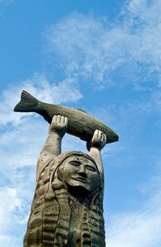 wood carved statue, woman holding fish