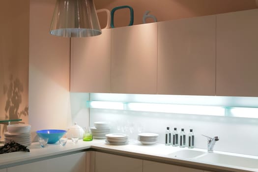 modern beige kitchen with blue tureen and shade on the wall