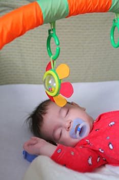 infant in red cloth sweetly sleeps