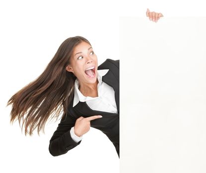 Blank sign woman. Excited businesswoman pointing empty billboard poster. Young business woman of mixed asian caucasian ethnicity. Isolated on white background.