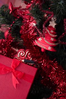 red gift box hanging on christmas tree