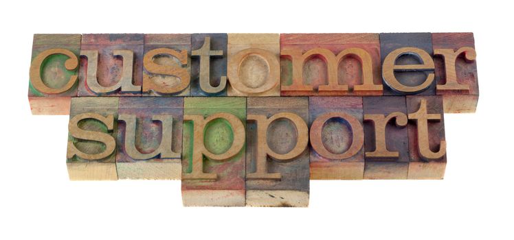 customer support word in vintage wooden letterpress type blocks, stained by color ink, isolated on white