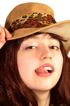 Young woman in hat shows tongue, isolated