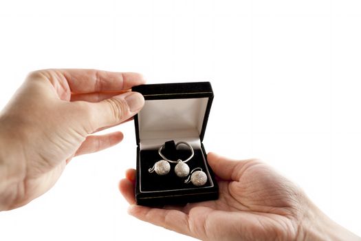 Female hands with open black box with silver necklace and earrings