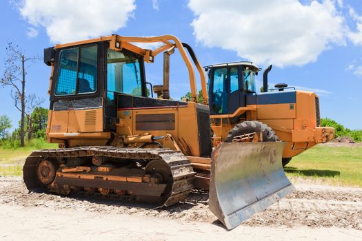 Bulldozer and loader on a job site blue sky