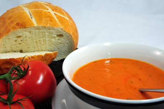 Hot Tomato soup in a bowl with bread on the side