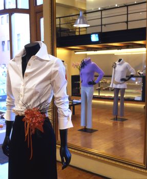 Interior of the fashionable shop with mannequin in white blouse