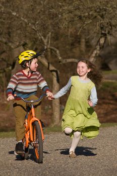 boy on bike, girl running beside him