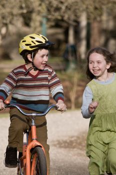 boy on bike, girl running beside him