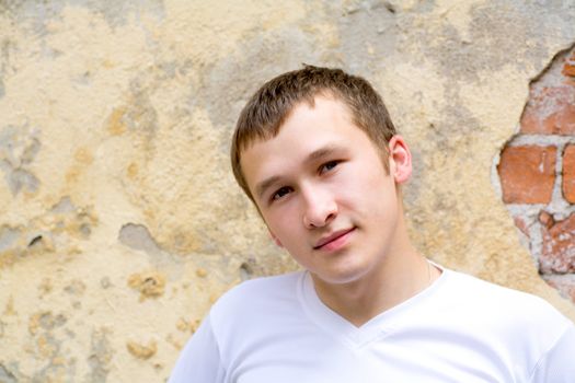 Portrait of Young man standing near grange wall