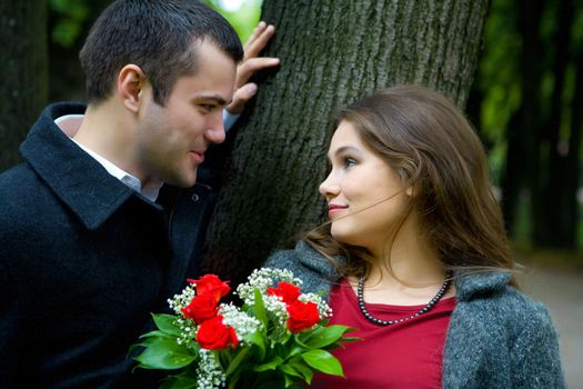 Two young lovers talking to each other in park