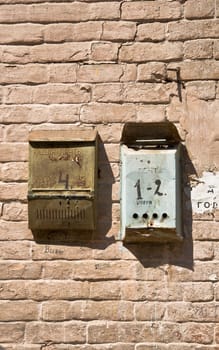 The old brick wall with mailboxes. Rusty metal and old brickwork. Close-up, fragment.