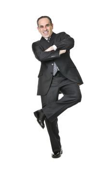 Happy businessman in a suit standing on one leg isolated on white background