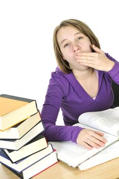 Yawning teenage girl studying at the desk