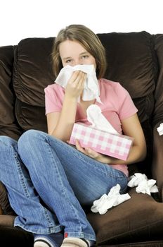 Teenage girl with a cold sitting in a chair with tissue box