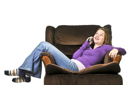 Teenage girl talking on a phone sitting in an armchair