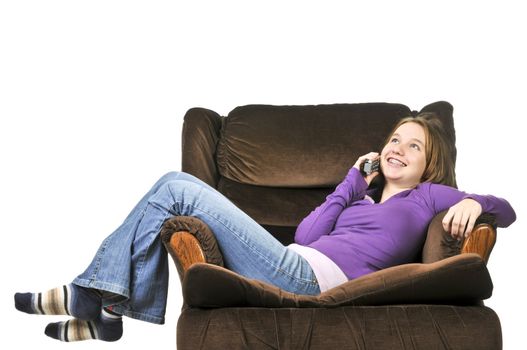 Teenage girl talking on a phone sitting in an armchair