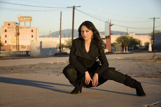 Beautiful woman iwearing black trenchcoat in urban setting