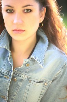 portrait of the beautiful brunette in jeans jacket