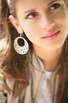 close-up portrait of the beautiful young brunette in silver earring