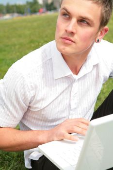 youth with green eye keeps in hand laptop