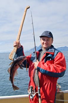 Fisherman with fish on the boat near the Lofoten island