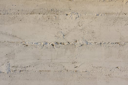 white painted concrete wall with pattern from wood planks used in construction