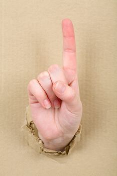 Gesture female hand through from hole in cardboard