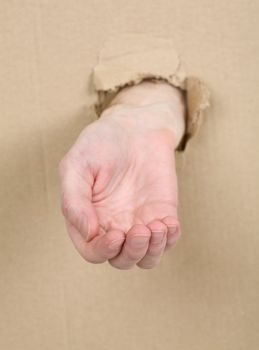 Male hand through from hole in cardboard