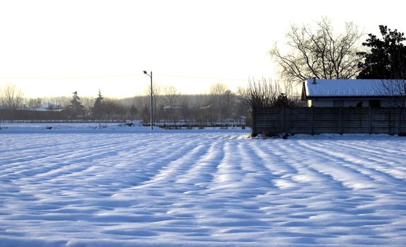 Landscape full of snow with lights of sunset on the background