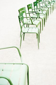 Parisian metallic chairs in the city park. Photo with tilt-shift lens