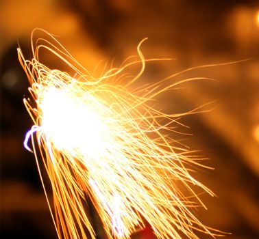 A firework shines on a blurry yellow and orange background