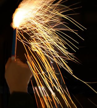 Hand of a child holding a shining firework