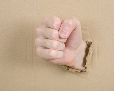 Gesture male hand through from hole in cardboard