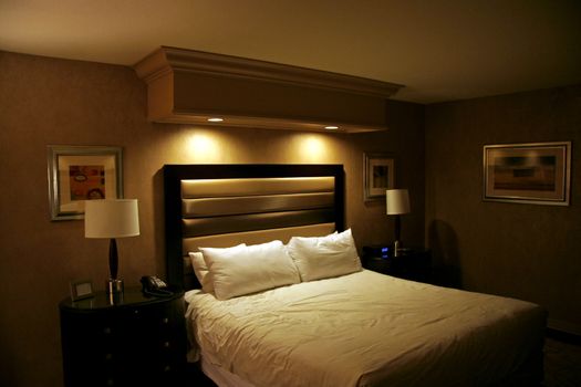 A hotel room bed with clean white sheets