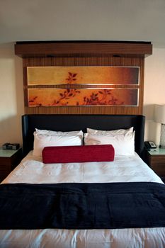 A hotel room bed with clean white sheets