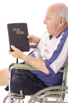 elderly man in wheelchair reading the bible