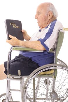 old man in wheelchair reading a bible